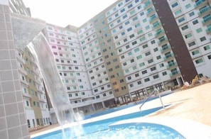 Ein mehrstöckiges Hotel mit Schwimmbad und Wasserspiel.