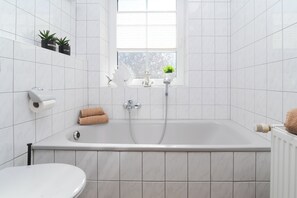 シャワー付き浴槽、ヘアドライヤー、トイレットペーパー