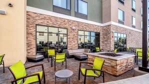 An outdoor patio area with seating, including chairs and a sofa, and a fire pit. - SpringHill Suites by Marriott Oakland Airport (Oakland)