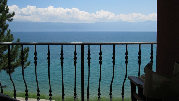 Un balcon avec vue sur la mer et les montagnes.