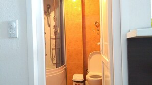 A bathroom with a shower, toilet, and sink.