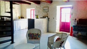A room with a dining area, a kitchen, and a living space.