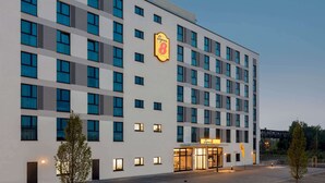 Een meerhoog hotel met een opvallend 'Super 8' logo, grote ramen en een goed verlichte ingang.