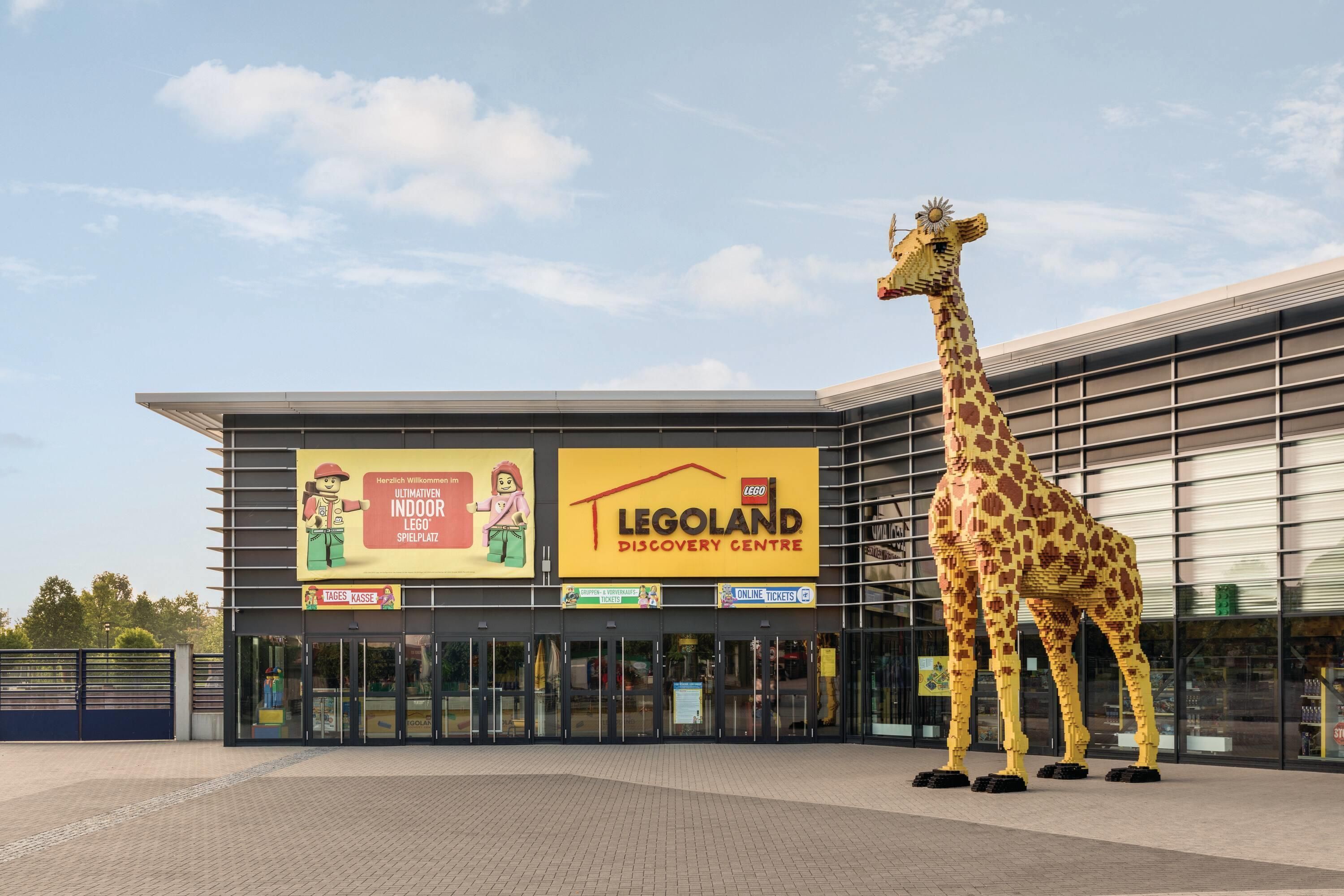 A LEGO Discovery Centre with a large LEGO giraffe sculpture in front.