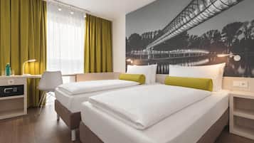 Een hotelkamer met twee bedden, een bureau, een stoel en een groot raam met gordijnen.