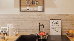 Eine Küche mit einer Kaffeestation, einem Schild mit der Aufschrift 'Kitchen is my favorite place' und einem Fenster mit Pflanzen.
