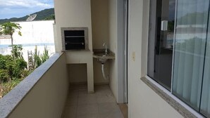 A small balcony with a sink and a window. - Residencial Malu (Penha)