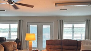 A living room with two brown sofas, a standing lamp, and a ceiling fan. - Arkansas River House at the Foot Hills of Petit Jean Mt. (Morrilton)