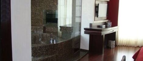 A modern bathroom with a granite countertop, a sink, and a mirror.