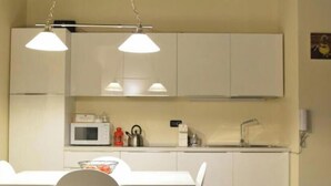 A compact kitchen with white cabinets, a microwave, a sink, and pendant lighting. - SCIESA 24 APARTMENTS - CIR 023091-LOC-01674 - CIN IT023091C2RKYIHNOG (Verona)