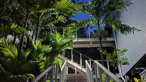 Un escalier avec des rampes en métal menant à l’entrée d’un bâtiment.