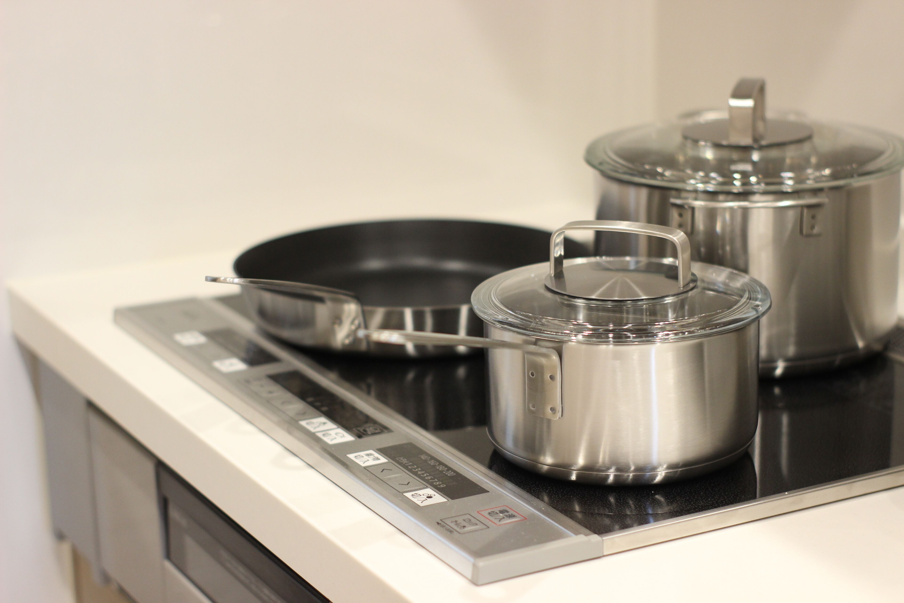 A stainless steel stove with pots and pans.