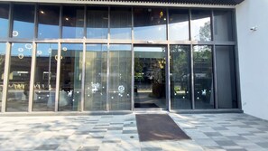 A modern building with large glass windows and a checkered tile floor.