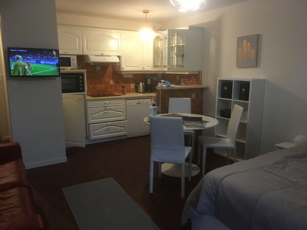 A compact hotel room with a kitchenette, a dining area, and a bed. - Ground floor studio (Crozon)