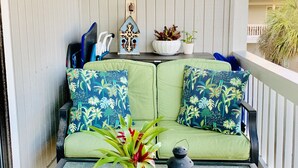 A balcony with a green sofa, a small table with a plant, a lantern, and a sign reading "SEAGROVE BEACH". - Steps to 30A & beach with all the comfort of home including a washer & dryer!  (Santa Rosa Beach)