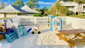A beach area with play structures, a picnic table, and a white picket fence. - Steps to 30A & beach with all the comfort of home including a washer & dryer!  (Santa Rosa Beach)