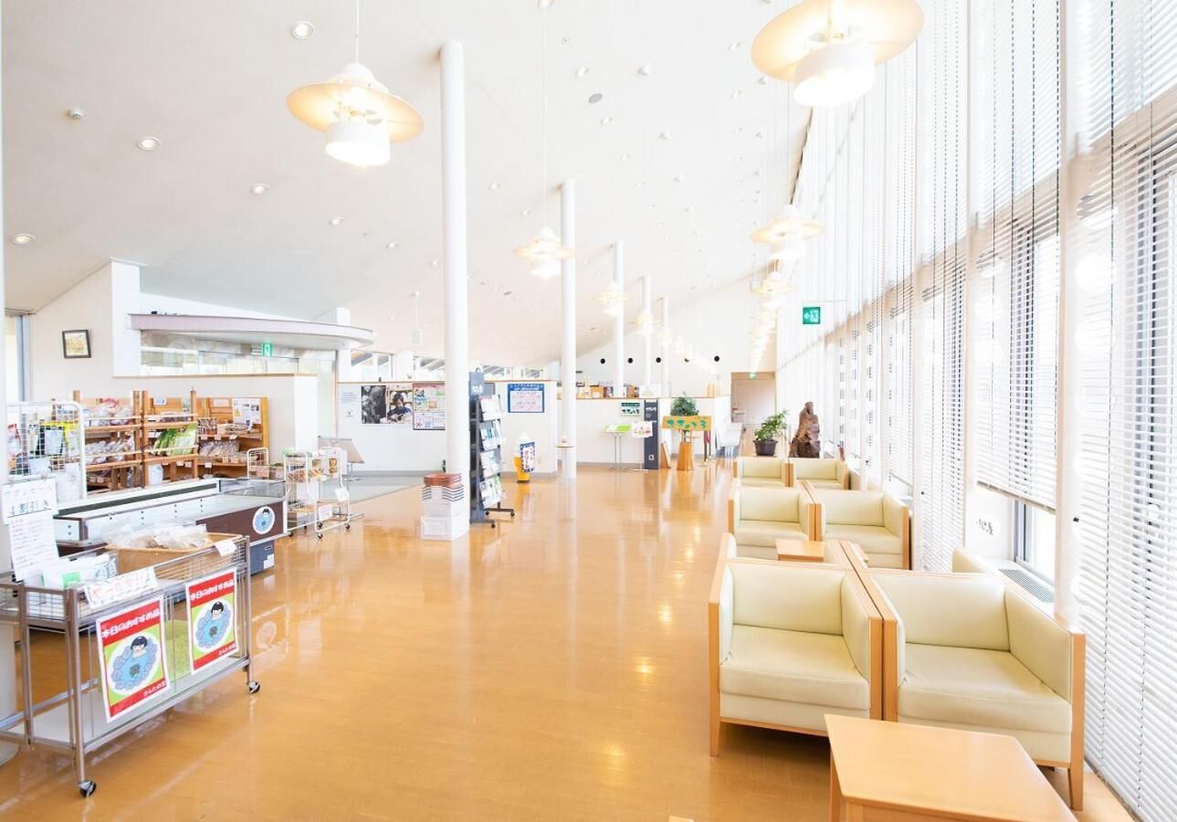 A spacious indoor area with seating arrangements and a counter with informational displays.