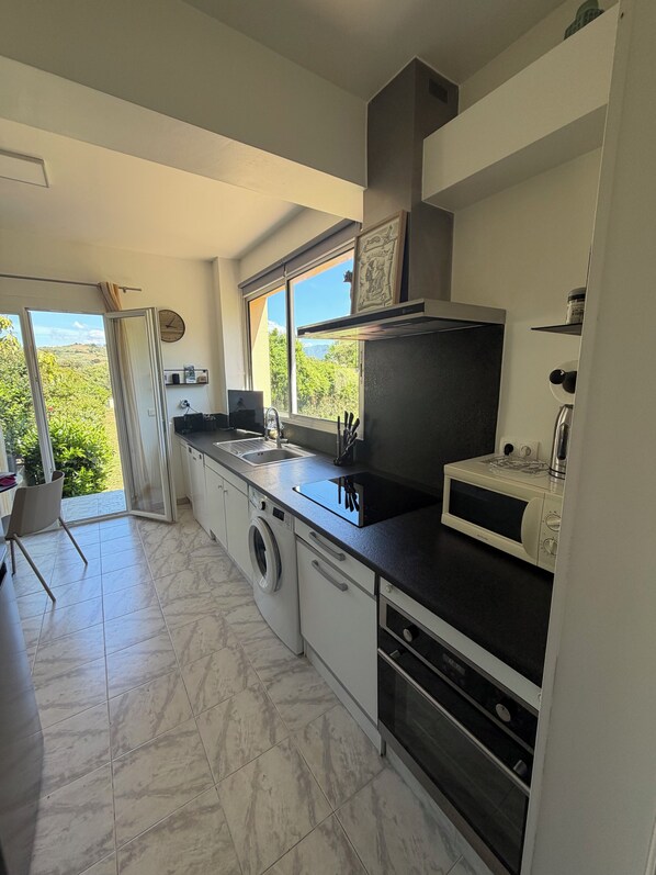 A modern kitchen with a built-in oven, microwave, and sink.