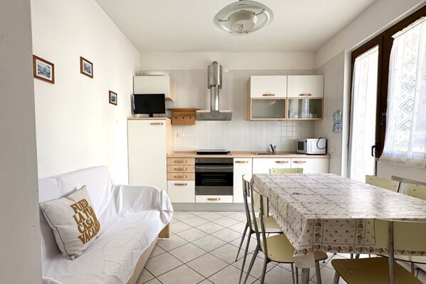 A compact kitchen with a microwave, oven, and a dining area with a table and chairs.
