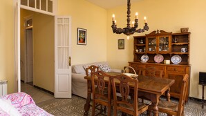 A dining area with a wooden table and chairs, a chandelier, and a china cabinet. - Terraced house at the beach. Barcelona. Free Wifi (Canet de Mar)