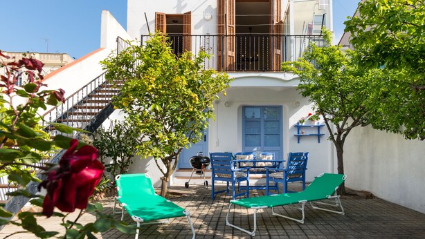 A two-story building with a balcony, outdoor seating area, and a staircase leading to the upper floor. - Terraced house at the beach. Barcelona. Free Wifi (Canet de Mar)