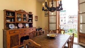 A dining area with a wooden table, chairs, a cabinet with glass doors, and a chandelier. - Terraced house at the beach. Barcelona. Free Wifi (Canet de Mar)