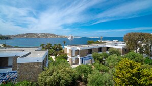 A coastal building with a view of the sea and a lighthouse in the distance. - Central suites (Mykonos)