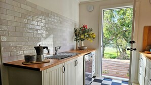A kitchen with a checkered floor, a sink, and a coffee maker. - The Mia Mia Newstead - Pet Friendly Country Retreat close to town (Newstead)
