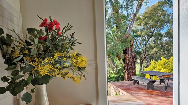 A room with a wooden table, a bowl, and a vase with flowers. - The Mia Mia Newstead - Pet Friendly Country Retreat close to town (Newstead)