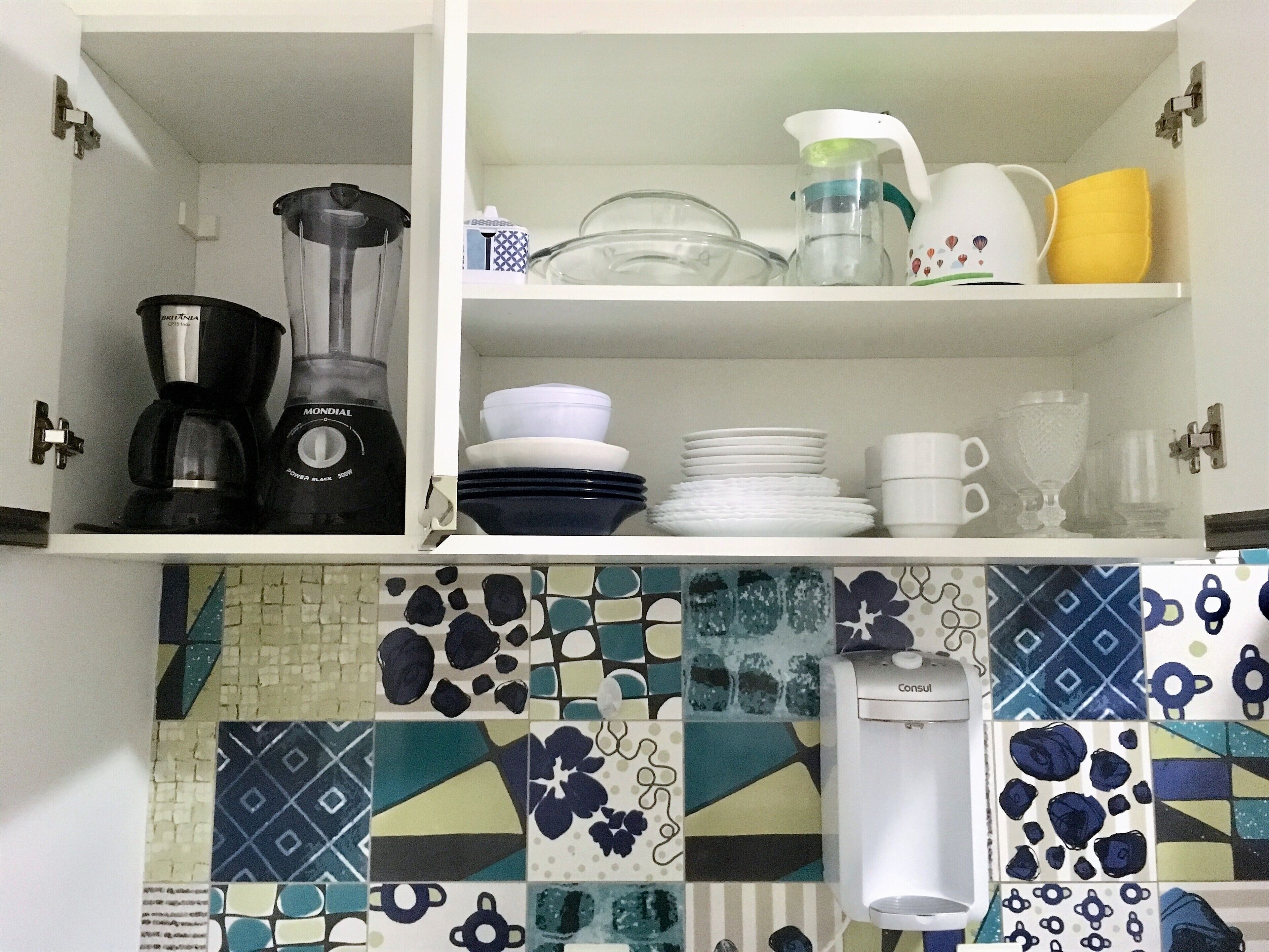 A kitchen with a coffee maker, a blender, and a water dispenser on the countertop.