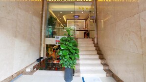 The entrance of the Lucky Star Hotel with a marble staircase leading up to the reception area. - Lucky Star Hotel 266 De Tham (Ho Chi Minh City)
