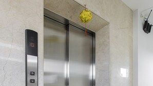 A modern elevator with a digital display, a marble wall, and a clean, reflective floor. - Lucky Star Hotel 266 De Tham (Ho Chi Minh City)