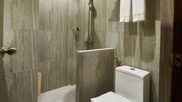 A modern bathroom with a shower, toilet, and towel rack.