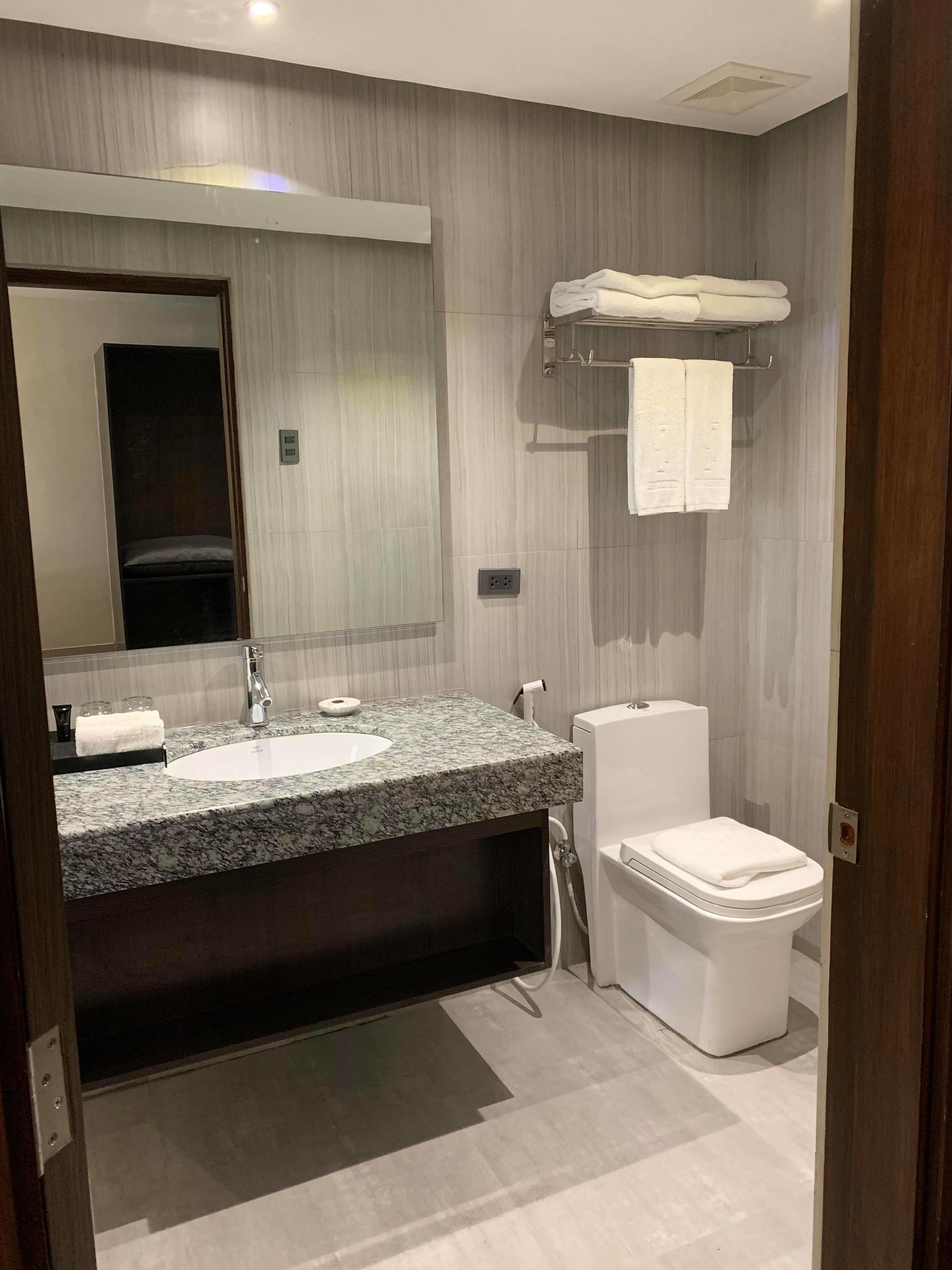 deluxe king room | bathroom | shower, slippers, towels