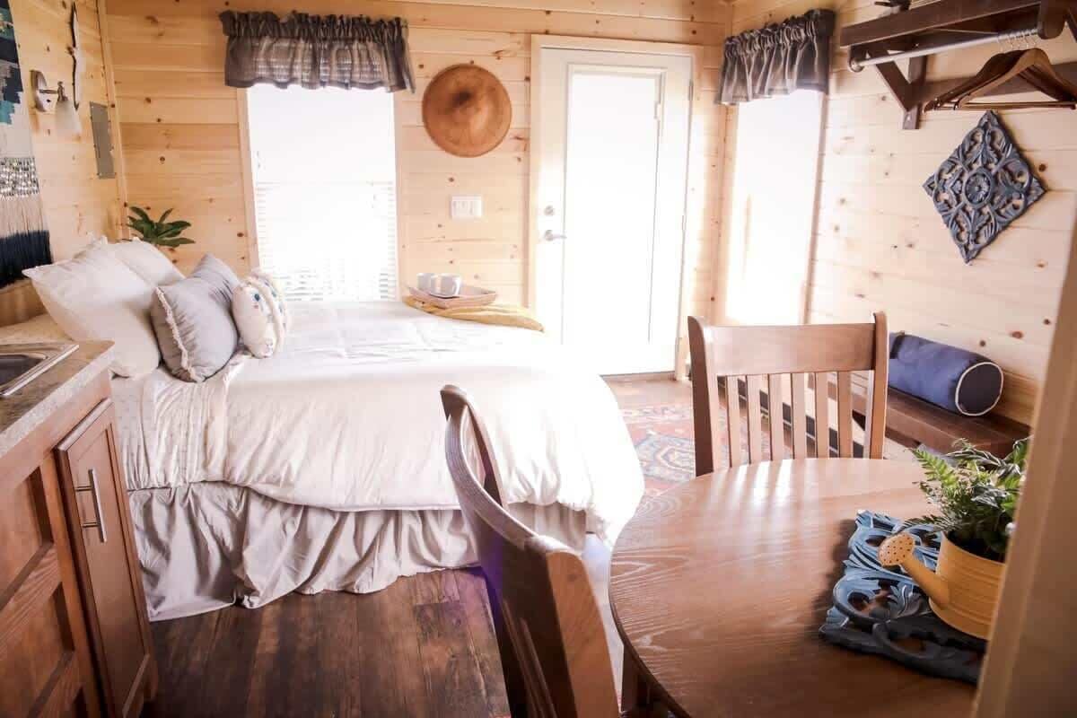 Um quarto acolhedor em estilo cabana, com cama, mobiliário de madeira e um espaço para refeições.