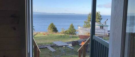 A view from a window overlooking a grassy area with a boat named "MARGARET B" and picnic tables.