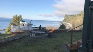 A boat named 'MARGARET' docked near a grassy area with a fire pit and picnic table.