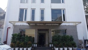 Un immeuble à plusieurs étages doté d’une façade sobre, de grandes fenêtres et d’une entrée centrale.
