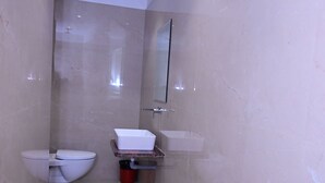 Une petite salle de bain comprenant des toilettes, un lavabo et un miroir.