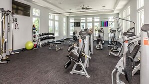 A gym with various exercise machines, dumbbells, and a ceiling fan. - Closest to the Beach @ Lost Key + Game Room (Pensacola)