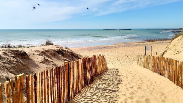 A sandy beach with a wooden fence leading to the water. - Charming Renovated House with Garden, 300m from Beach, WiFi Included (Bretignolles-sur-Mer)