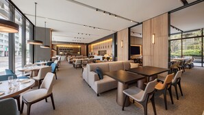 Un ristorante moderno con varie opzioni di posti a sedere, tra cui tavoli, banconi e un'area bar.