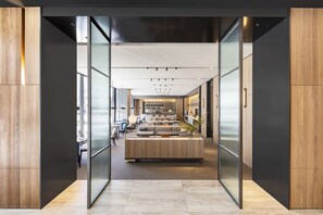 A modern hotel lobby with a central seating area, glass partitions, and a view of the cityscape. - Parkview Taipei (Taipei)