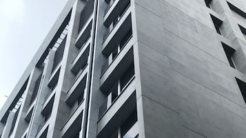 A high-rise building with a modern architectural design, featuring a grid of windows and balconies.