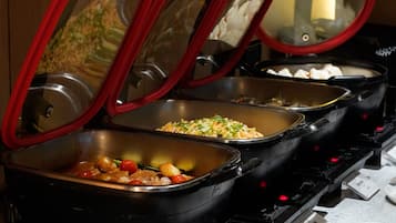 A buffet with multiple food stations, each with a red lid and a stainless steel interior.