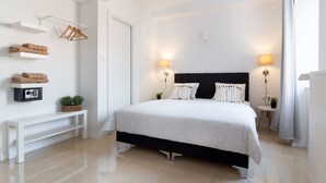 A modern bedroom with a bed, bedside tables, a bench, and wall-mounted towel racks. - B&B Downtown Zagreb (Zagreb)