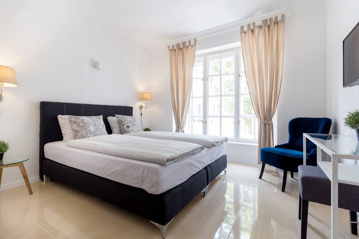 Une chambre à coucher moderne avec un grand lit, un bureau et une chaise.
