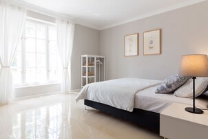 Un dormitorio con cama, mesita de noche, lámpara y armario.