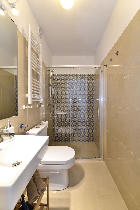 Un baño moderno con ducha, inodoro y lavamanos.