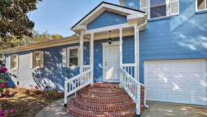 A two-story house with a front porch, a garage, and a brick staircase leading to the front door. - Spacious Mount Pleasant Home: 5 Mi to Beach (Mount Pleasant)